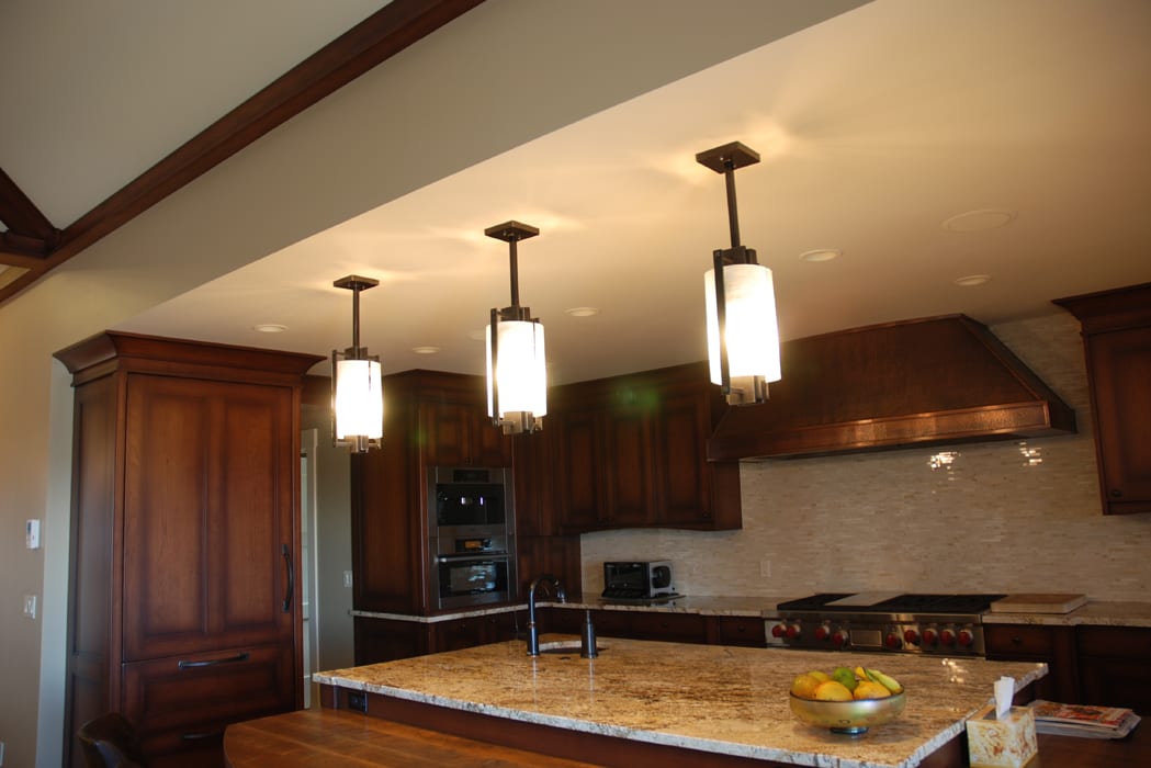 A kitchen with three lights hanging above the island.