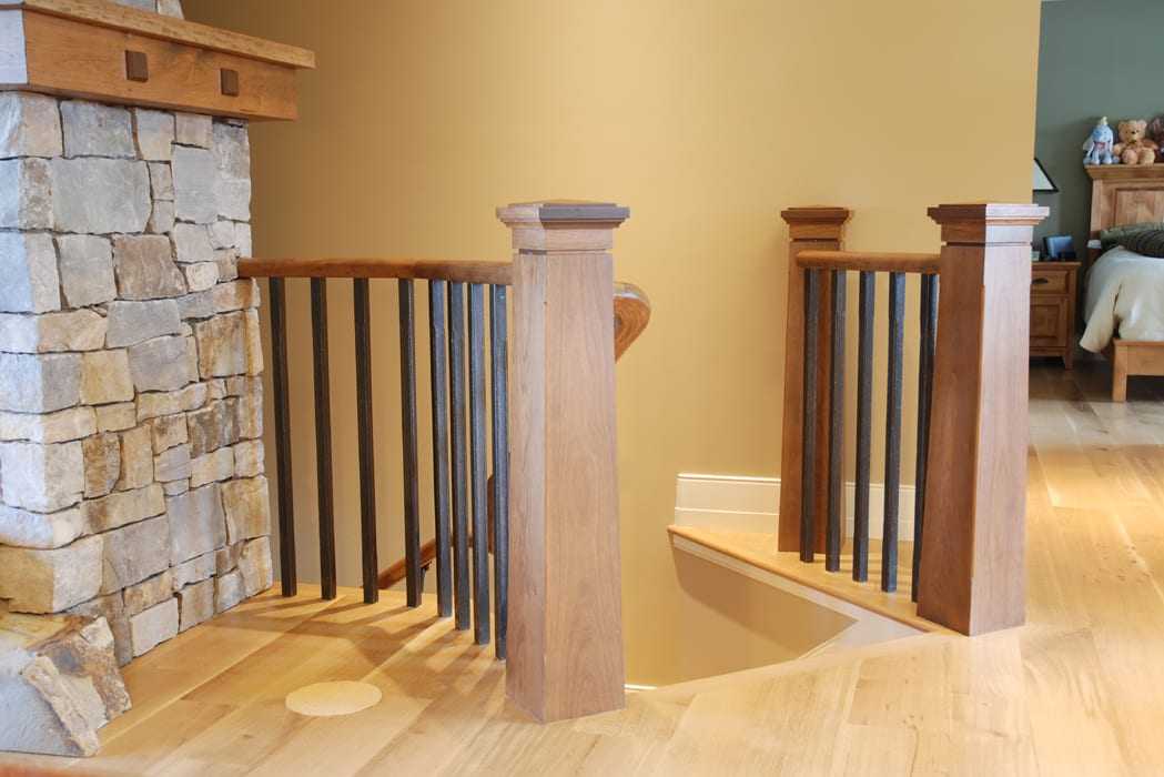 A wooden railing with metal posts on each side of the stairs.