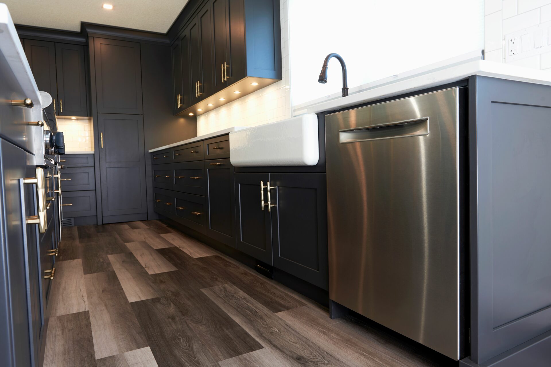 A kitchen with black cabinets and stainless steel appliances.