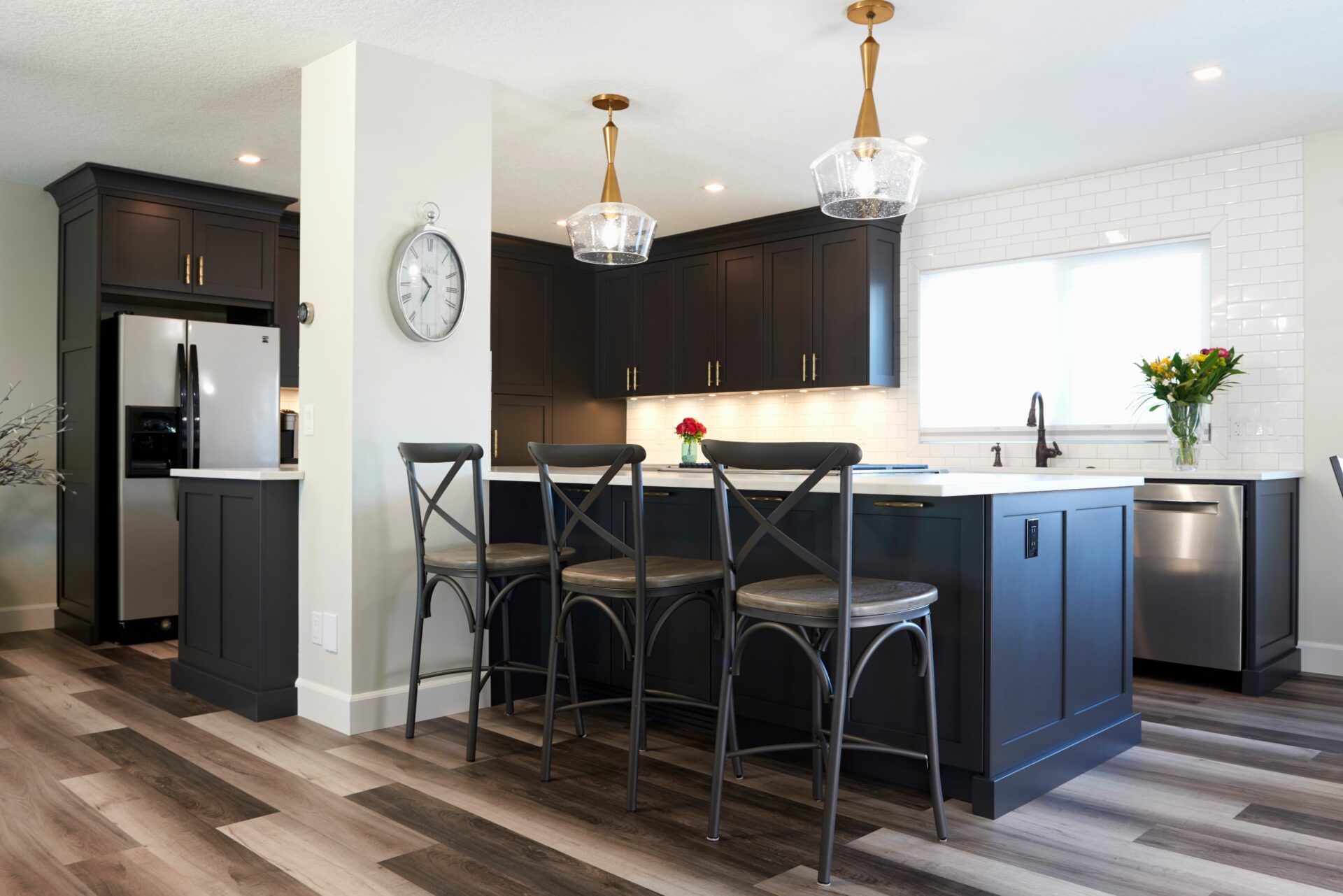 A kitchen with black cabinets and white walls.