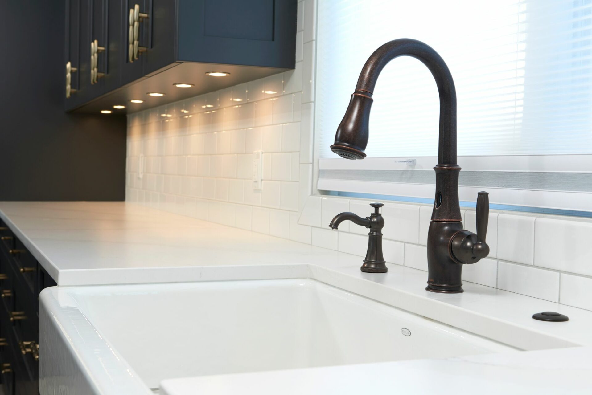 A white sink and black faucet in a kitchen.