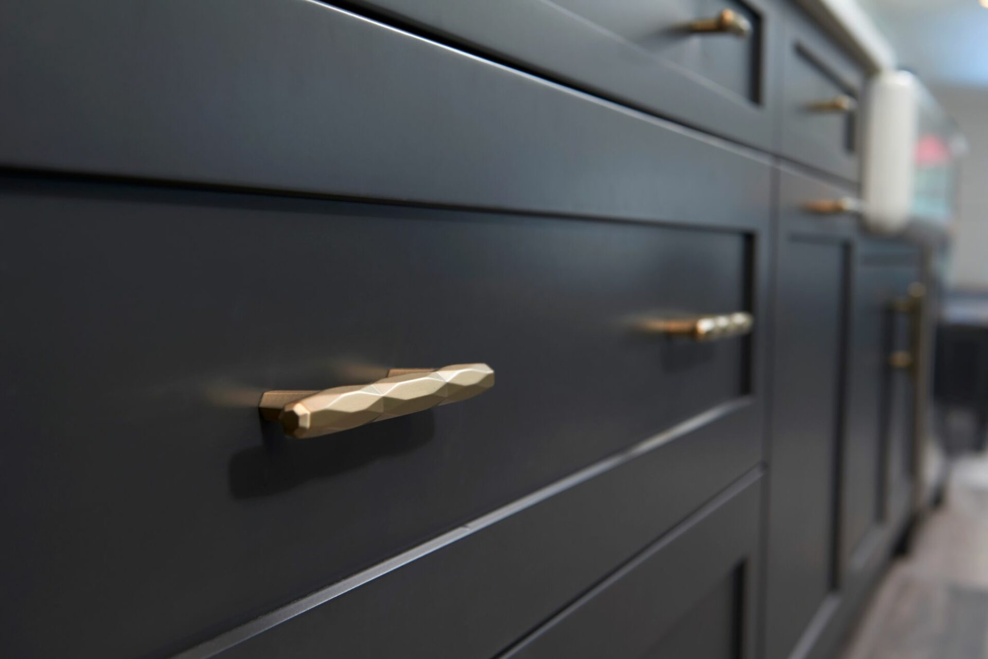 A close up of the handles on a black cabinet